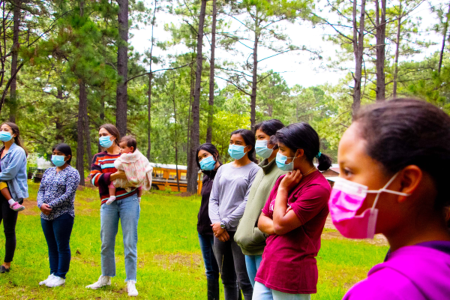 Projekt Honduras grupp kvinnor som lyssnar med ansiktsmasker